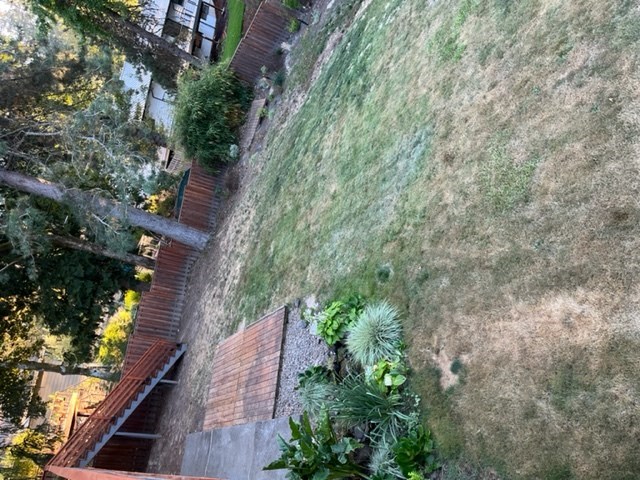an aerial view of a yard with a wall and stairs