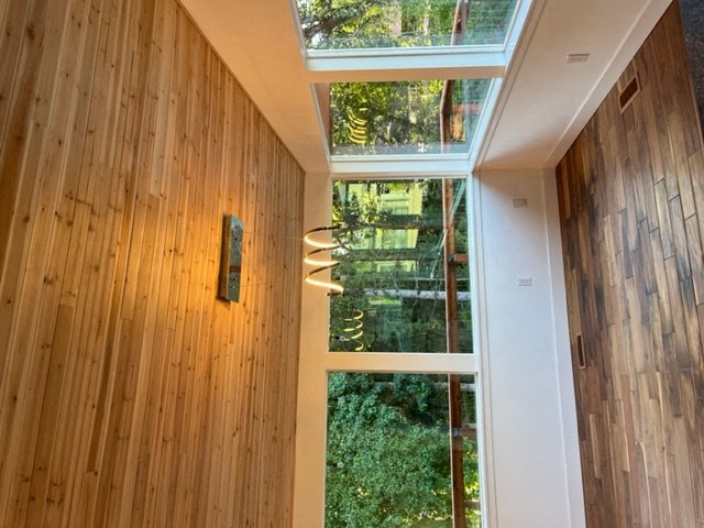 a view of a hallway with a large window and a wooden wall