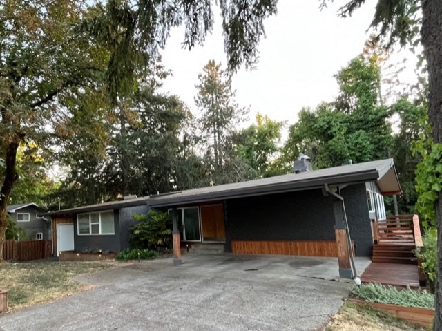 the front of a house with a driveway and stairs