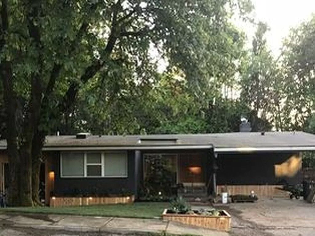 a house with a yard and trees in front of it