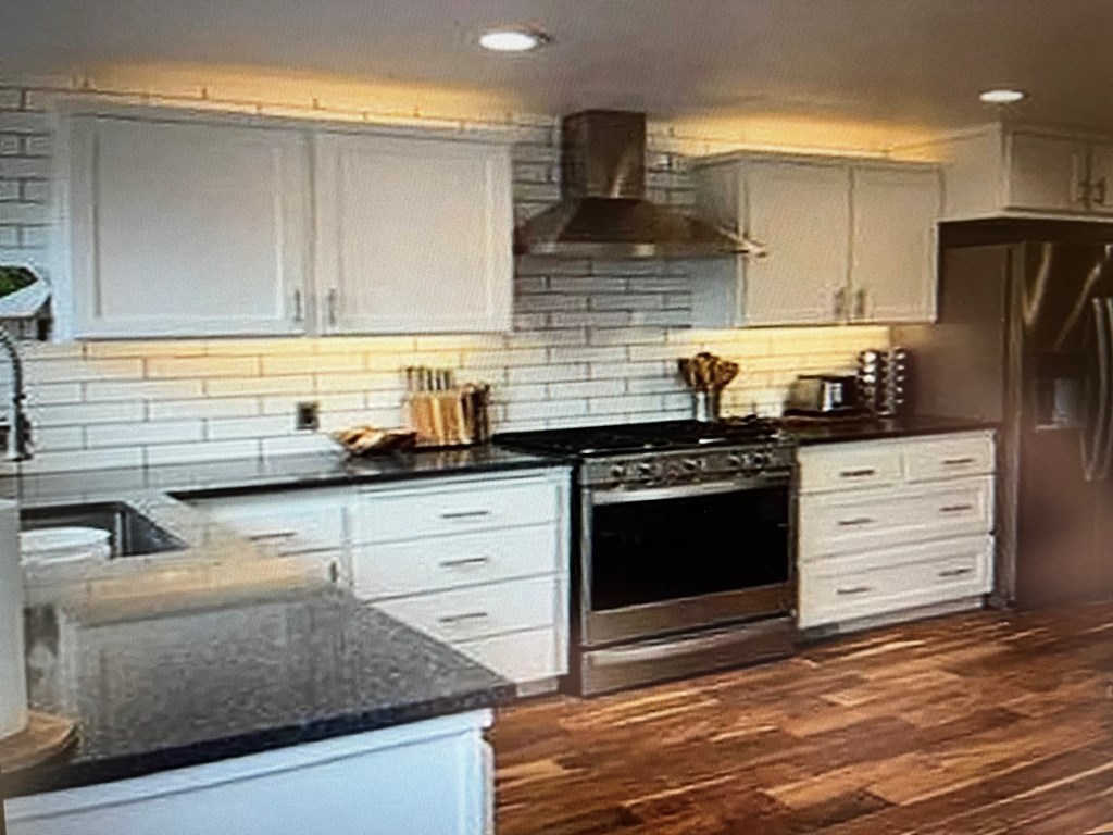 a kitchen with white cabinets and a stove top oven