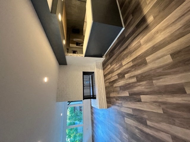 a hallway of a house with wooden floors and a large window
