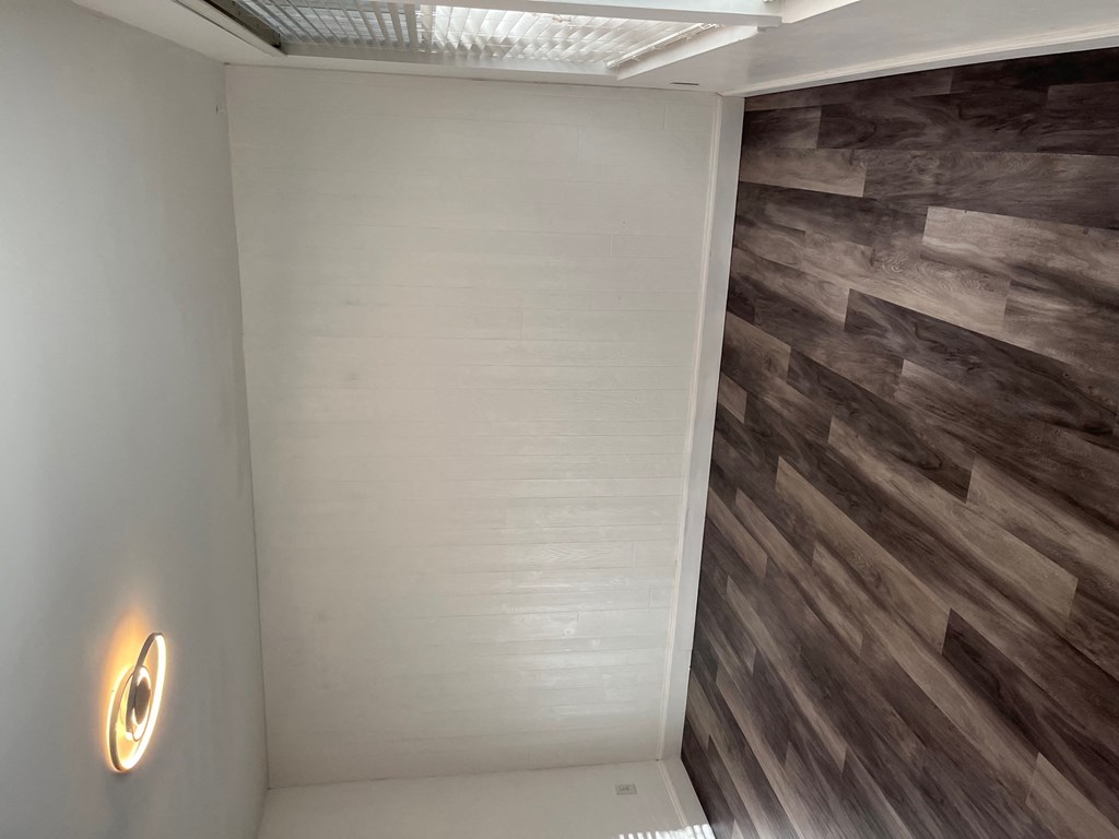 a small bathroom with a shower and wood flooring