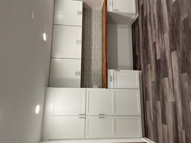 a bathroom with white cabinets and a mirror