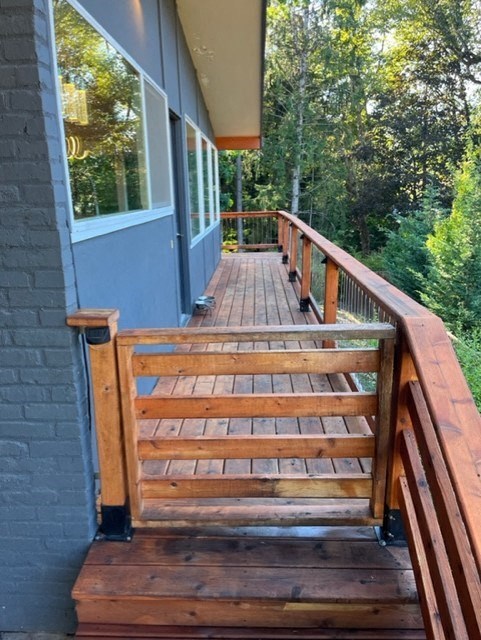 a porch with a wooden deck and a blue house