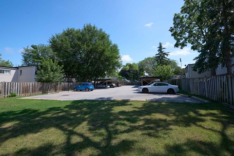 A blue car is parked in a driveway.