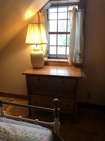 a bedroom with a bed and a lamp and a window