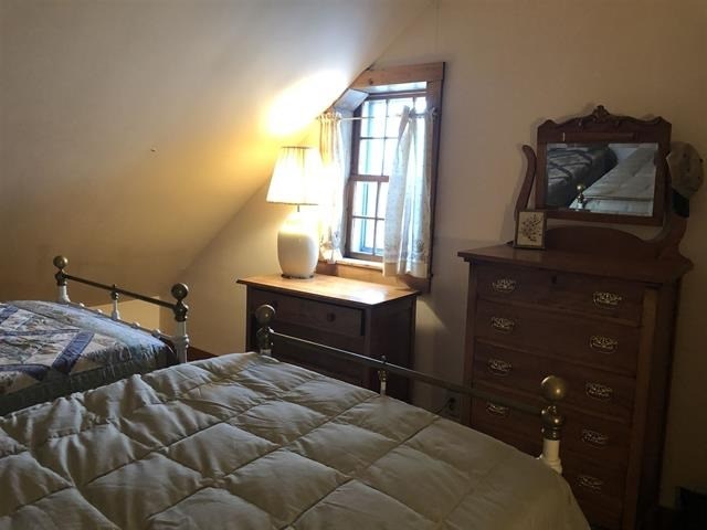 a bedroom with a bed and a dresser and a mirror