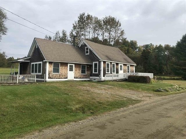 a house with a dirt road in front of it