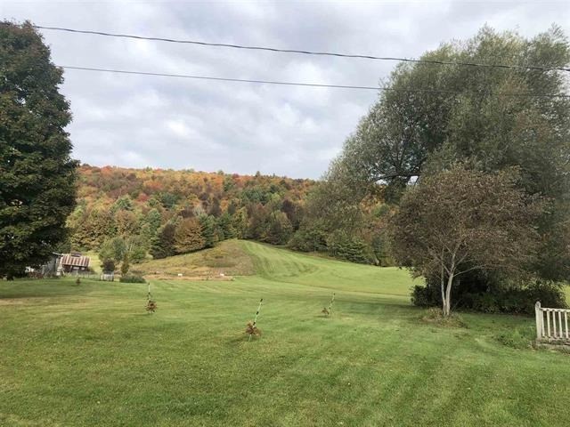 a grassy field with a hill in the background