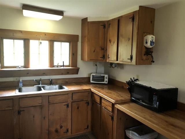 a kitchen with wooden cabinets and a sink and a microwave