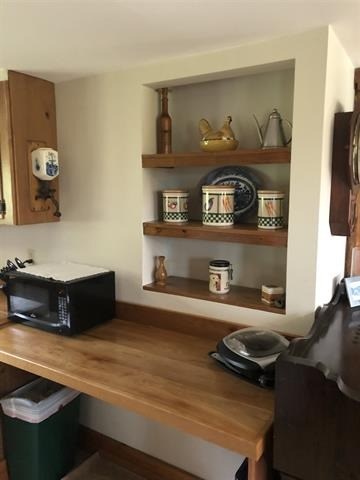 a small kitchen with a microwave and shelves