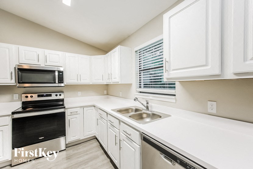 A kitchen with white cabinets and a stainless steel dishwasher.