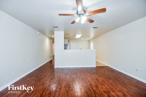 a living room with wood flooring and a ceiling fan