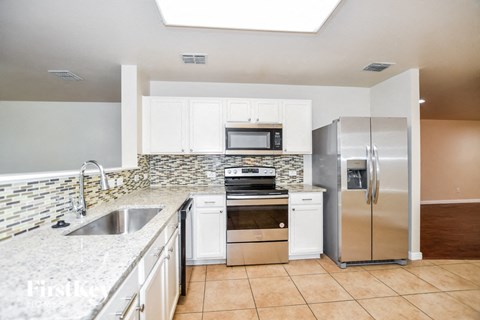 a kitchen with white cabinets and stainless steel appliances