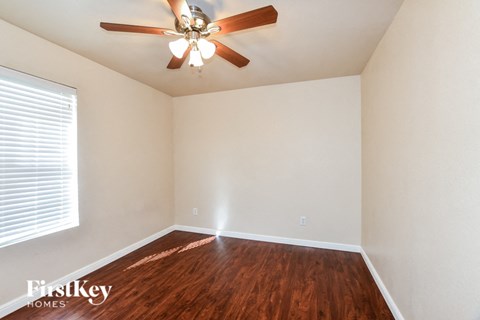 an empty room with a ceiling fan and a window