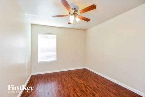 a living room with hardwood floors and a ceiling fan