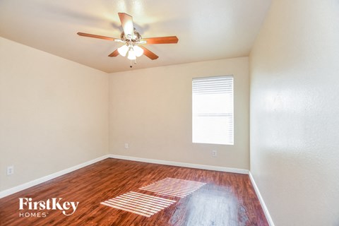 an empty room with a ceiling fan and a window