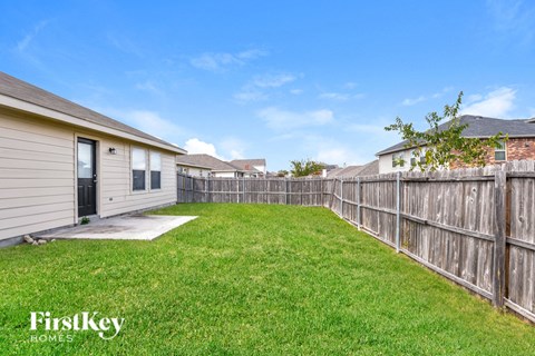 the backyard of a house with a yard and a fence