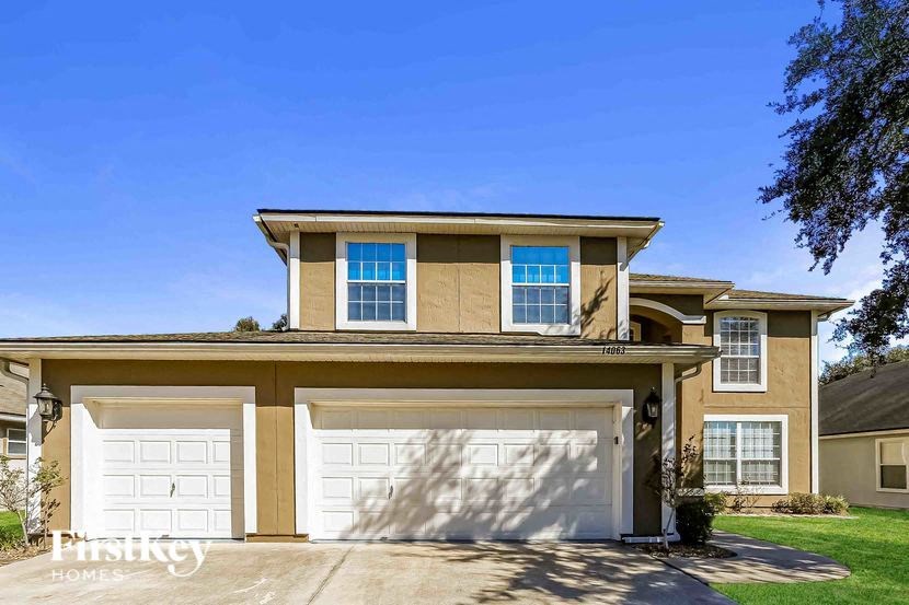 A two-story house with a garage and a driveway.