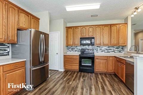 A kitchen with wooden cabinets and a stainless steel refrigerator.
