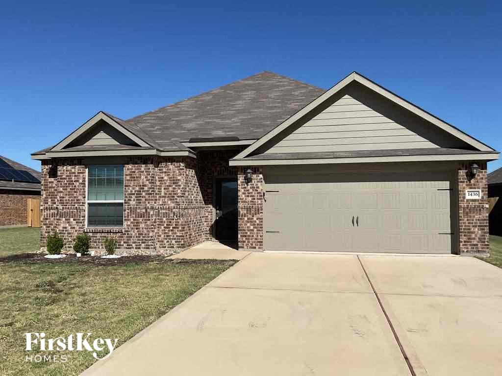 A house with a garage and a driveway in front of it.