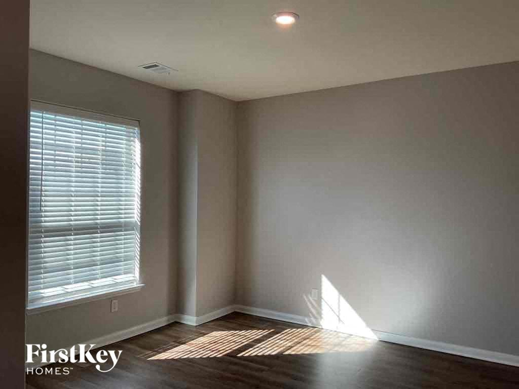 A room with a window and wooden flooring.