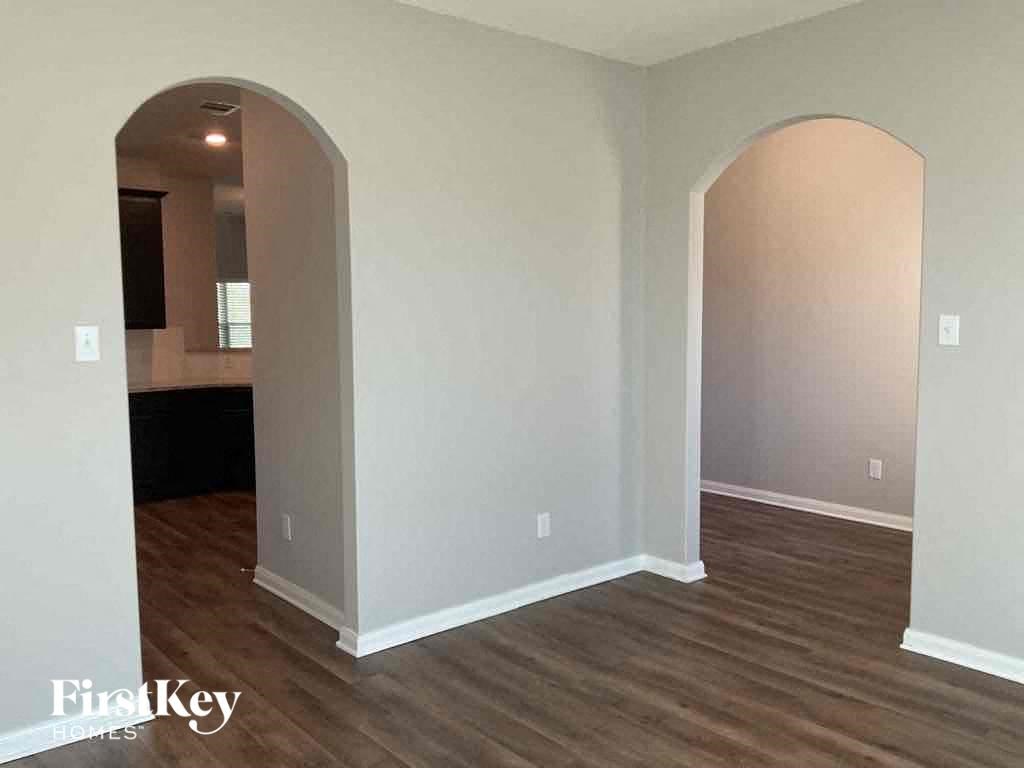 A room with wooden floors and arched doorways.