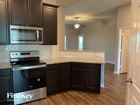 A kitchen with dark brown cabinets and a stainless steel oven.