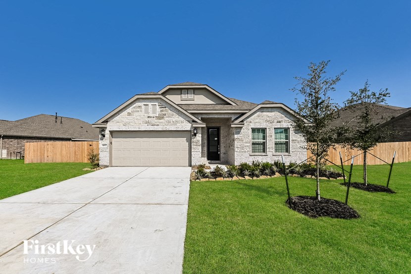a white brick home with green grass and a sidewalk in front of it
