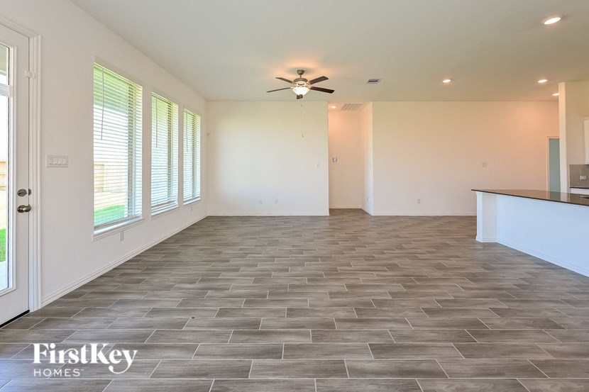 the living room of an empty house with a ceiling fan