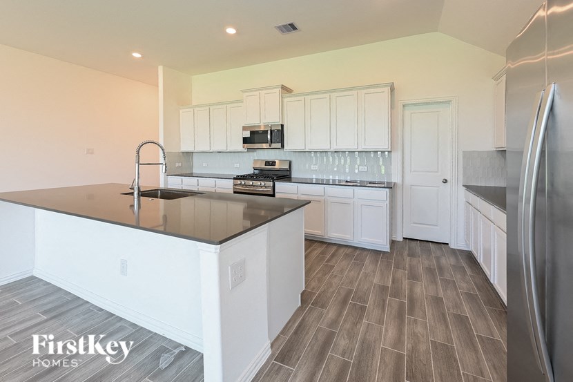 a kitchen with white cabinets and stainless steel appliances