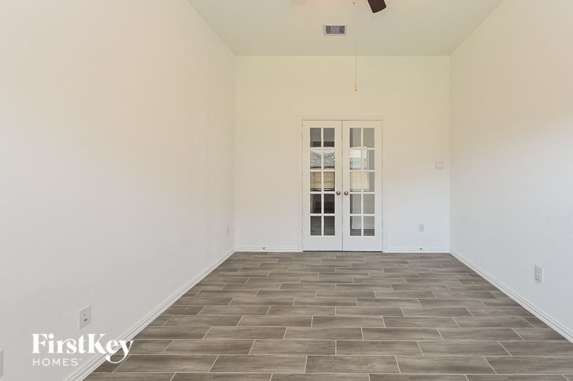 the living room of a house with white walls and a gray tile floor