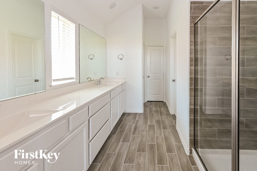 a large white bathroom with two sinks and a shower