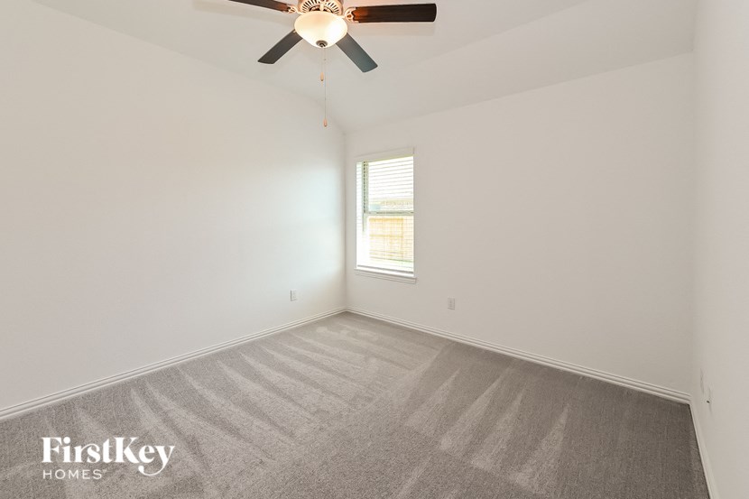 the living room of an empty house with a ceiling fan