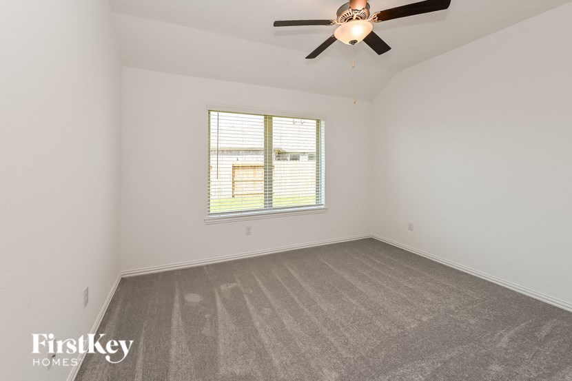 a bedroom with a ceiling fan and a window