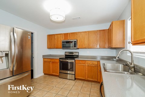 A kitchen with wooden cabinets and a stainless steel refrigerator.