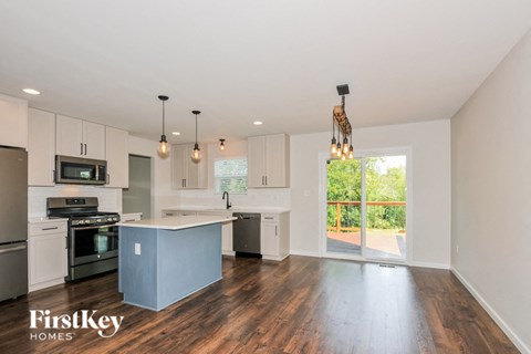 A kitchen with a blue island and wooden floors.