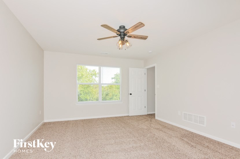 A room with a ceiling fan and a window.