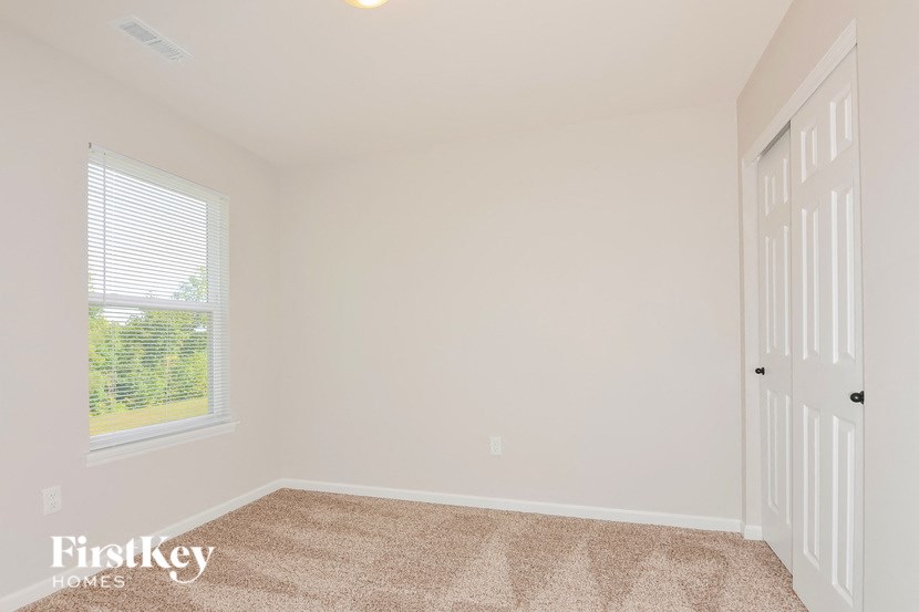 A room with a carpeted floor and a door on the right side.