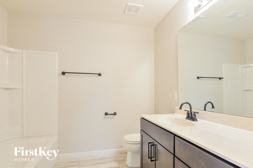 A bathroom with a white toilet, a sink, and a mirror.