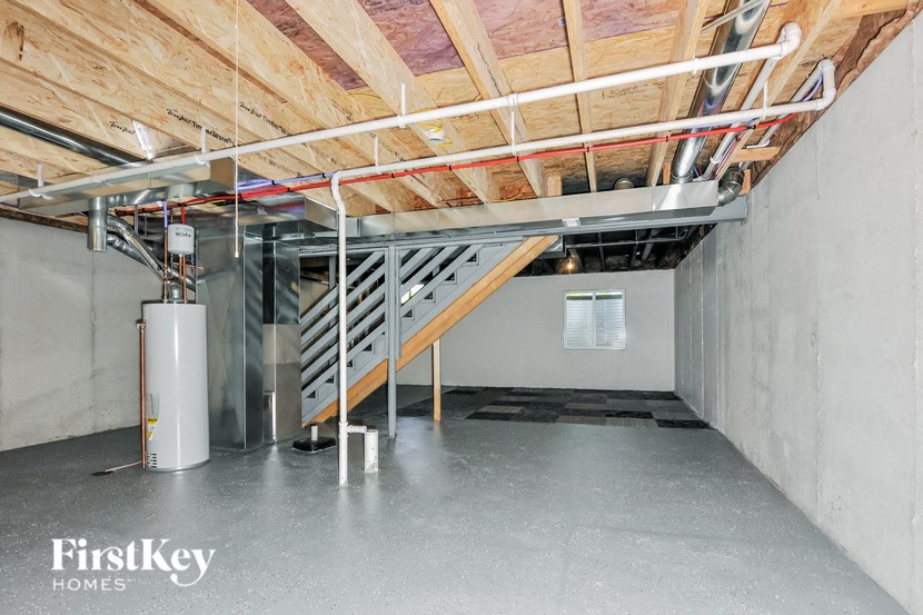 A room under construction with a staircase and a FirstKey Homes logo.