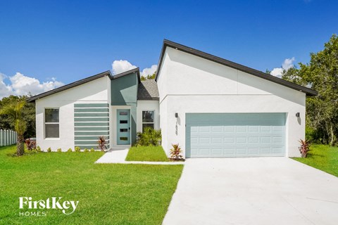 A modern house with a garage door is for sale by FirstKey Homes.