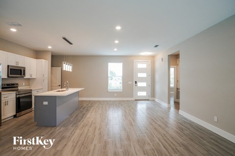 A spacious kitchen with wooden floors and a modern design.