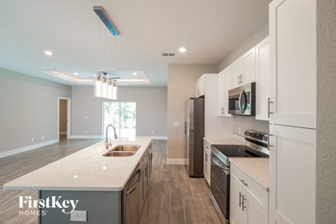 A modern kitchen with white cabinets and a wooden island.