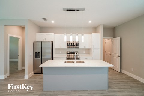A kitchen with a white countertop and a refrigerator.