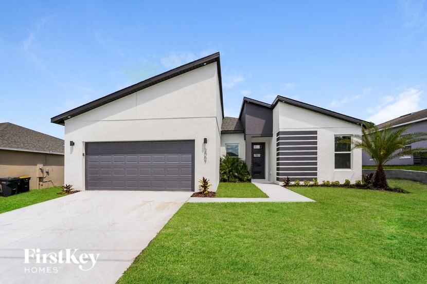 A modern house with a grey garage door and a white exterior.