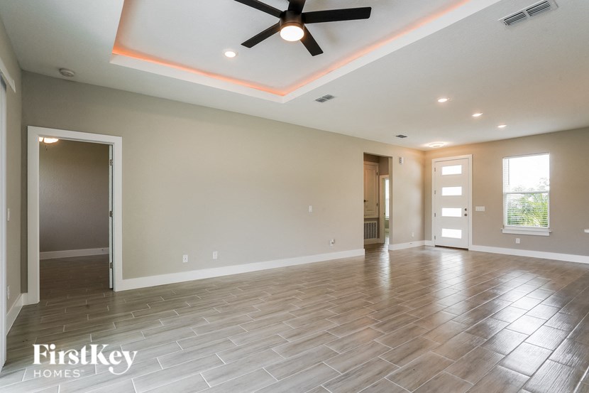 A spacious room with a ceiling fan and lighting fixtures.