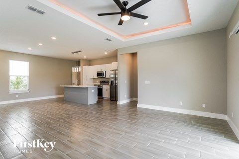 A spacious room with a kitchen island and a ceiling fan.