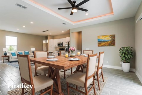A dining room with a wooden table and chairs.